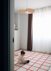 Rear view of woman sitting on wall