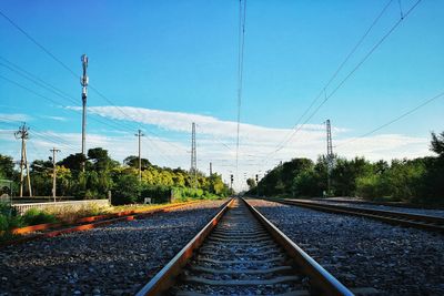 Railroad tracks and power lines against sky