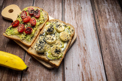 Healthy breakfast toasts with avocado toast, tomato, banana, yoghurt with whole grain sandwich bread