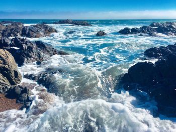 Scenic view of rocks in sea against sky