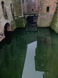 High angle view of old bridge over canal amidst buildings