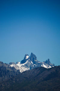Scenic view of snowcapped mountains against clear blue sky