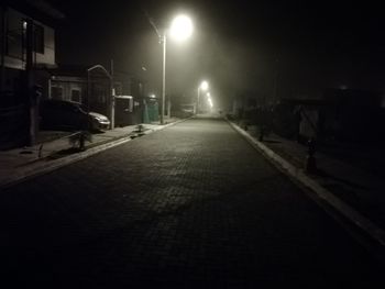 Street amidst illuminated city at night