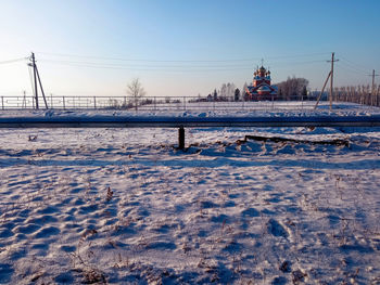 Snow covered field with a church 