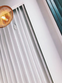 Low angle view of electric lamp hanging on ceiling