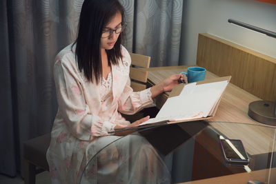 Woman sitting on table at home