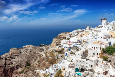 High angle view of buildings on mountain by sea against sky