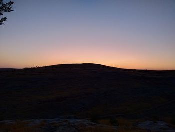 Scenic view of silhouette landscape against clear sky during sunset