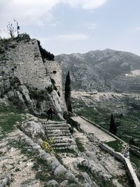 Person walking on stairs against landscape