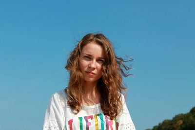 Portrait of woman against blue sky