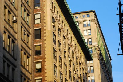 Low angle view of buildings against clear blue sky