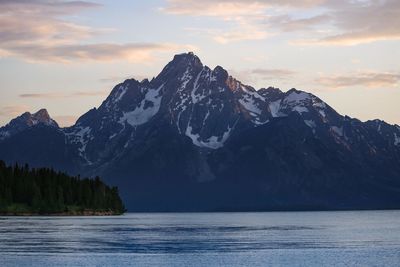 Scenic view of sea and mountains against sky during sunset