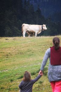 Mother and daughter looking at cow