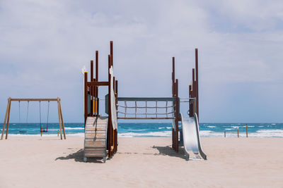 Wooden posts on beach against sky