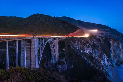 Arch bridge against blue sky at night