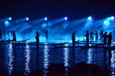 People in blue sky at night
