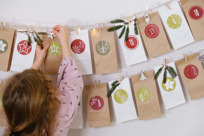 Toddler child gets new advent calendar task, waiting for christmas. festive mood for cute curly girl