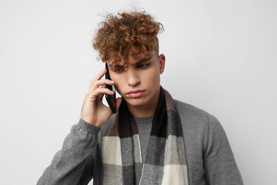 Young woman using mobile phone against white background