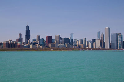 City at waterfront against clear sky