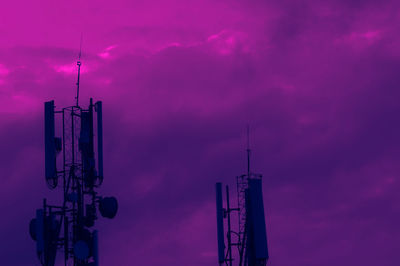 Low angle view of communications tower against sky at sunset