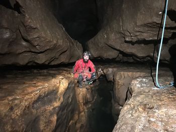 Portrait of man sitting on rock in cave