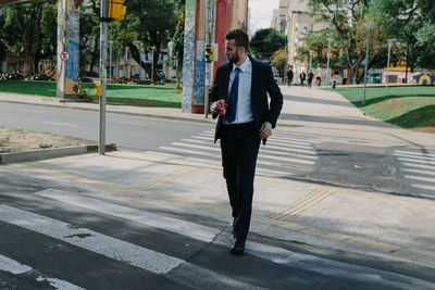 Man walking on footpath in city