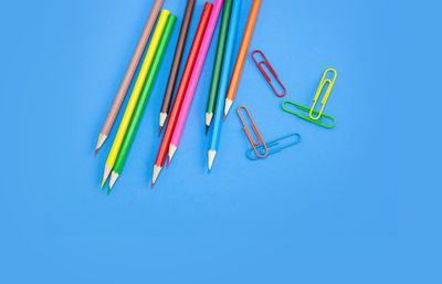 High angle view of colored pencils against blue background