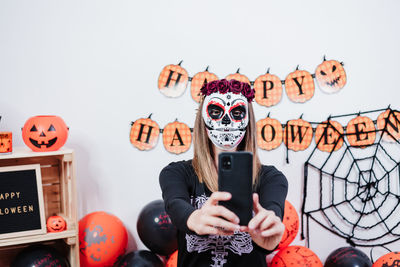 Full length portrait of person holding mask