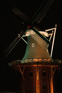 Low angle view of traditional windmill against sky at night