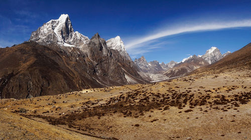 Scenic view of mountains against blue sky