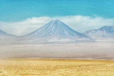 Scenic view of snowcapped mountain against cloudy sky