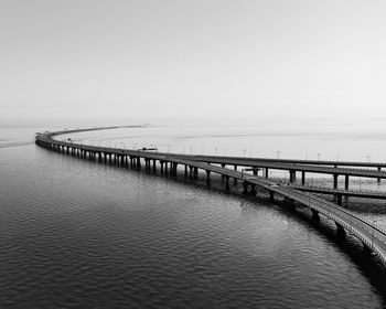 Bridge over sea against clear sky