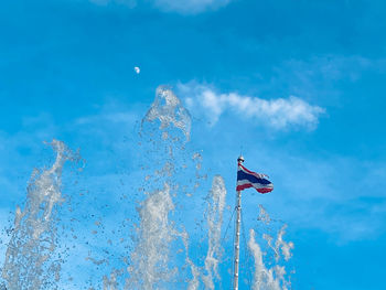 Man flying against blue sky