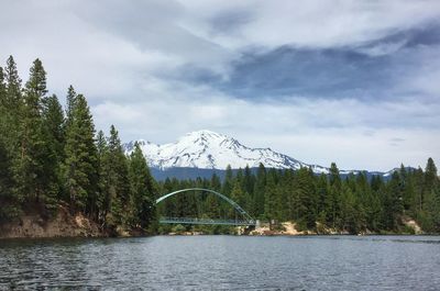 Bridge over river against cloudy sky