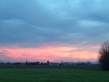 Scenic view of field against cloudy sky