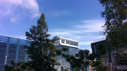 Low angle view of trees and buildings against sky