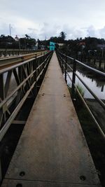 Surface level of footbridge over canal against sky