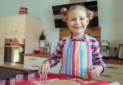 Smiling girl making cookies at home