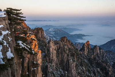 Panoramic view of rocks and mountains against sky during sunset