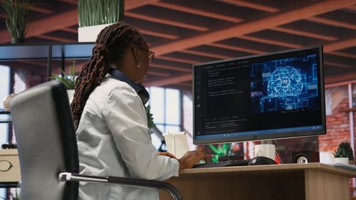 Side view of young woman using digital tablet in office