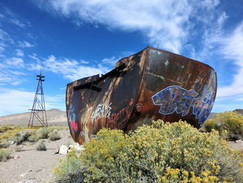 Abandoned boat against cloudy sky