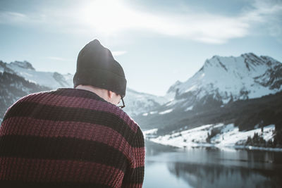 Rear view of man looking at snowcapped mountain