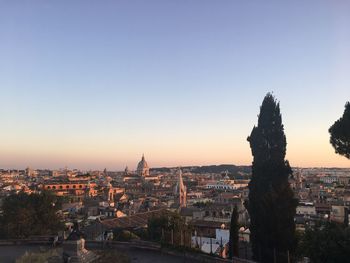 Illuminated buildings in city against clear sky