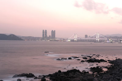 Bridge over sea against sky during sunset