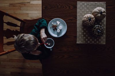 High angle view of boy having food and drink at table