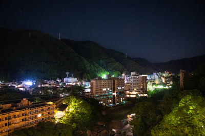 High angle view of illuminated buildings against sky at night