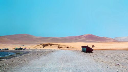 Scenic view of desert against blue sky