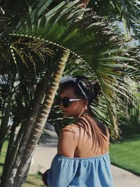 Man wearing sunglasses standing by plants