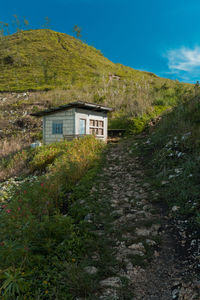 House by mountain against sky