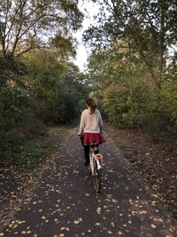 Woman riding bicycle against trees